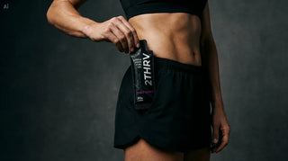 Close view of a 2THRV whole-food energy gel held in a dark studio
