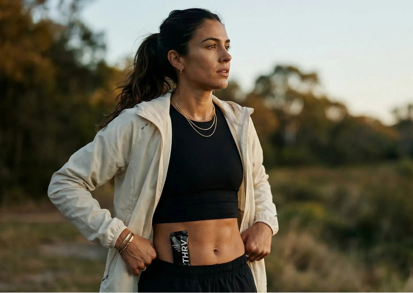 Woman in athletic wear standing outdoors with a scenic background